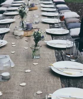 Mesa de banquete rústica y larga decorada con flores silvestres